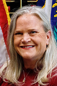 Portrait of Jennifer Scutchfield in front of the American and Kentucky flags.